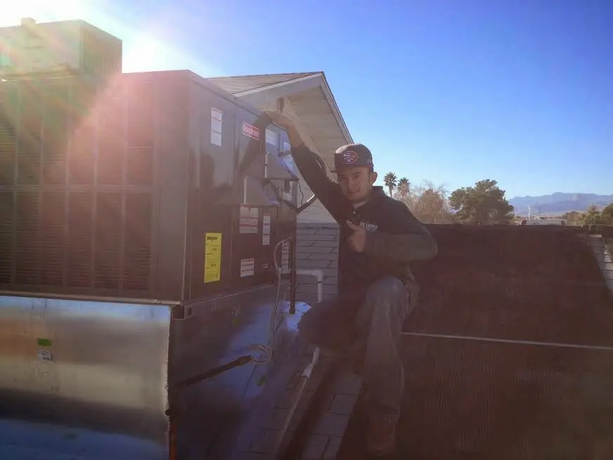 HVAC technician performing AC Tune-Up on a rooftop unit in Green Cove Springs